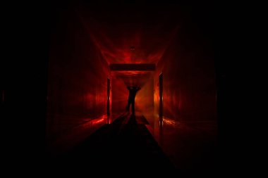 Ürpertici siluet koyu terk edilmiş binada. Manyak genel kavram ya da kabine kapılar ile karanlık koridor ve ışıkları ile farklı pozlar duran korkunç korku kişi silueti ile ilgili korku.