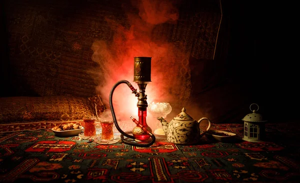 水烟碗上的水烟热煤制作阿拉伯内部的蒸汽云 东方饰品在地毯东方茶道 时尚的东方水烟在黑暗中与背光 选择性聚焦 — 图库照片