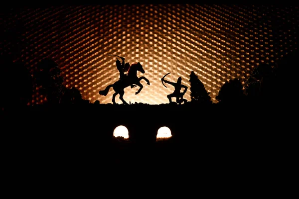 中世纪战斗场面在桥梁与骑兵和步兵 人物剪影作为分开的对象 战斗在黑暗色调的雾背景的勇士之间 夜场面 选择性聚焦 — 图库照片