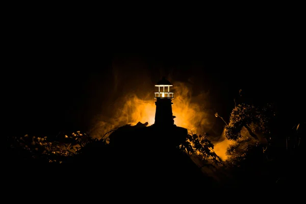 灯塔与光束在夜间与雾 矗立在山上的旧灯塔 餐桌装饰 色调的背景 选择性聚焦 — 图库照片