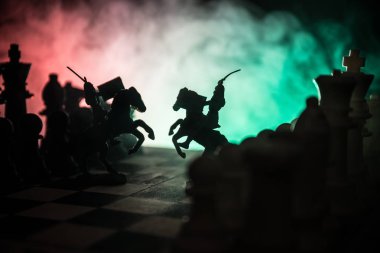 Süvari ve satranç tahtası üzerinde piyade ile ortaçağ savaş sahnesi. Satranç oyununu kavramı iş fikirleri ve rekabet ve strateji fikirler duman ve sis karanlık bir arka plan üzerinde satranç figürleri.