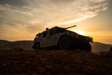 Gün batımı arka plan üzerinde askeri devriye arabası. Ordu savaş kavramı. Eylemde silahlı ve zırhlı silüeti. Dekore edilmiş. Seçici odak