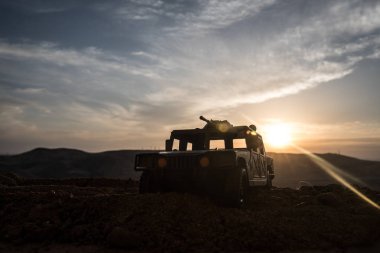 Gün batımı arka plan üzerinde askeri devriye arabası. Ordu savaş kavramı. Eylemde silahlı ve zırhlı silüeti. Dekore edilmiş. Seçici odak