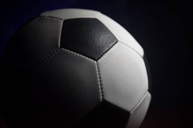 Futbol topu görünümünü koyu arka plan üzerine kapatın. Futbol oyun kavramsal atış. Seçici odak