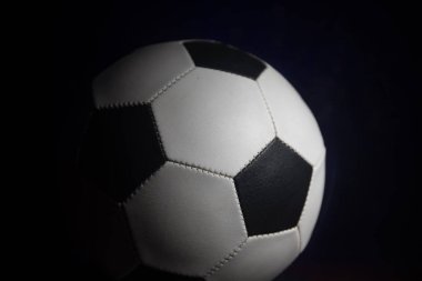Futbol topu görünümünü koyu arka plan üzerine kapatın. Futbol oyun kavramsal atış. Seçici odak
