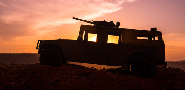 Военная патрульная машина на фоне заката. Военная концепция армии. Силуэт бронированного автомобиля с оружием в действии. Награжден. Селективный фокус
