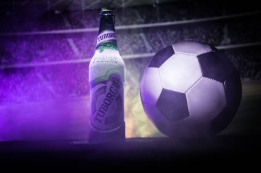 Bakü, Azerbaycan - 15 Haziran 2018: Yaratıcı kavramı. Tuborg çim futbol topu ve arka plan üzerinde bulanık Stadyumu ile cam şişe bira. Tuborg Kuzey banliyösü olan Kopenhag, Danimarka