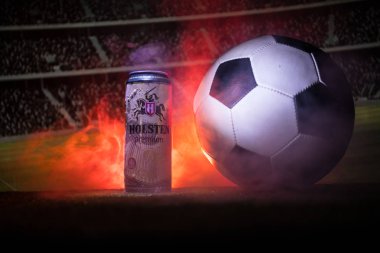 Bakü, Azerbaycan - 15 Haziran 2018: Yaratıcı kavramı. Futbol topu ve bulanık Stadyumu ateşi bulutlar ile arka plan üzerinde çim Tuborg cam şişe bira. Tuborg Kuzey banliyösü olan Kopenhag, Danimarka