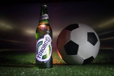 Bakü, Azerbaycan - 15 Haziran 2018: Yaratıcı kavramı. Tuborg çim futbol topu ve arka plan üzerinde bulanık Stadyumu ile cam şişe bira. Tuborg Kuzey banliyösü olan Kopenhag, Danimarka