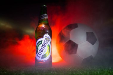 Bakü, Azerbaycan - 15 Haziran 2018: Yaratıcı kavramı. Tuborg çim futbol topu ve arka plan üzerinde bulanık Stadyumu ile cam şişe bira. Tuborg Kuzey banliyösü olan Kopenhag, Danimarka