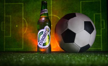 Bakü, Azerbaycan - 15 Haziran 2018: Yaratıcı kavramı. Tuborg çim futbol topu ve arka plan üzerinde bulanık Stadyumu ile cam şişe bira. Tuborg Kuzey banliyösü olan Kopenhag, Danimarka