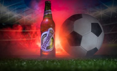 Bakü, Azerbaycan - 15 Haziran 2018: Yaratıcı kavramı. Tuborg çim futbol topu ve arka plan üzerinde bulanık Stadyumu ile cam şişe bira. Tuborg Kuzey banliyösü olan Kopenhag, Danimarka
