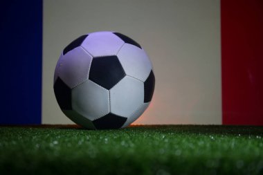Geleneksel futbol topu futbol sahası üzerinde. Yeşil çim ve Fransa bayrağı arka üzerinde futbol topu (futbol) görünümünü kapatın. Seçici odak