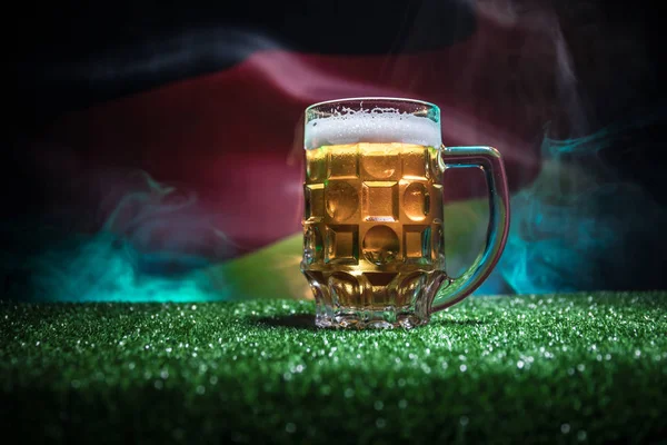 Conceito Criativo Uma Caneca Cerveja Fresca Grama Com Bandeira Borrada — Fotografia de Stock