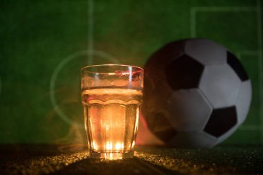 Yaratıcı kavramı. Bir bardak taze birayla sis ve ışık arka plan bulanık Stadyumu çimenlerin üzerinde. Bardak lager bira içmeye hazır. Uzay kopyalayın. Seçici odak