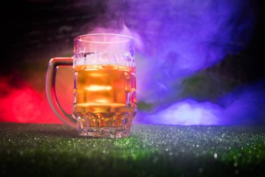 Yaratıcı kavramı. Bir bardak taze birayla sis ve ışık arka plan bulanık Stadyumu çimenlerin üzerinde. Bardak lager bira içmeye hazır. Uzay kopyalayın. Seçici odak