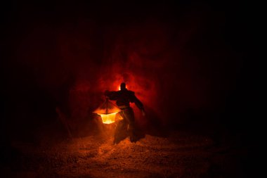 Yağmurluk ile onun el kavramı içinde parlayan fener karanlık ormanın gelen adam. Lamba korku katille silüeti. Dekorasyon