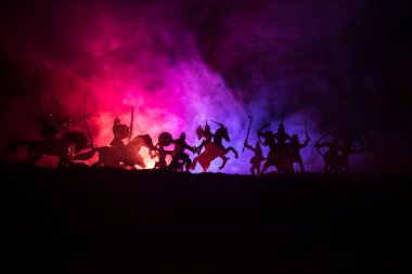 Süvari ve piyade ile ortaçağ savaş sahnesi. Siluetleri şekiller ayrı nesneler olarak mücadele koyu tonda sisli arka plan savaşçılar arasında. Gece sahne. Seçici odak