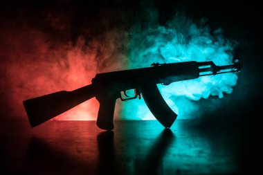 Saldırı tüfeği tonda sisli zemin üzerine silüeti. Savaş ya da antiterrorism kavramı. Rus askeri silah masada.