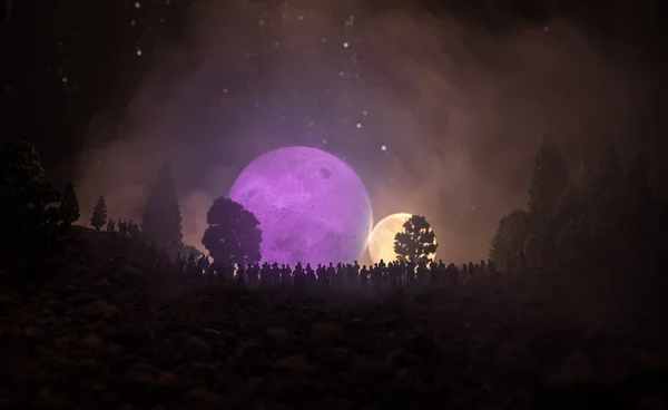 大勢の上昇の大きな満月を見て夜の森林で人のシルエット 夜空を背景に飾られた月と空間の要素 選択と集中 シュールな世界 — ストック写真