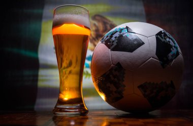 Bakü, Azerbaycan - 21 Haziran 2018: Resmi Rusya 2018 Dünya Kupası futbol topu Adidas Telstar 18 ve tek bira cam arka plan bulanık bayrağı ile. Ülkeniz bira konsepti ile destek.