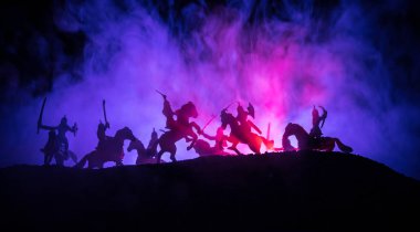 Süvari ve piyade ile ortaçağ savaş sahnesi. Siluetleri şekiller ayrı nesneler olarak mücadele koyu tonda sisli arka plan savaşçılar arasında. Gece sahne. Seçici odak