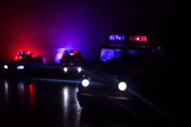 Geceleri polis arabaları. Polis arabası sisli bir arabayı gece takip ediyor. 911 acil durum arabası suç mahalline doğru hızla gidiyor. Seçici odak