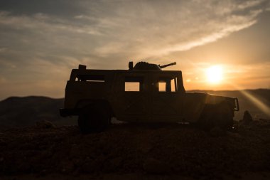 Gün batımı arka plan üzerinde askeri devriye arabası. Ordu savaş kavramı. Eylemde silahlı ve zırhlı silüeti. Dekore edilmiş. Seçici odak