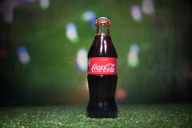 Bakü, Azerbaycan - 01 Temmuz 2018: Yaratıcı kavramı. Klasik Coca-Cola çimenlerin üzerinde cam şişede. Ülkeniz Dünya Kupası 2018 desteği. Seçici odak