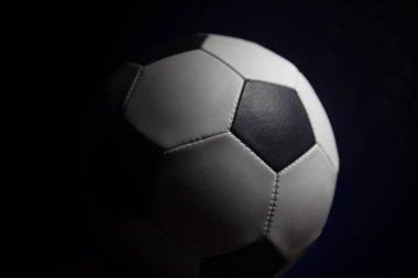 Futbol topu görünümünü koyu arka plan üzerine kapatın. Futbol oyun kavramsal atış. Seçici odak