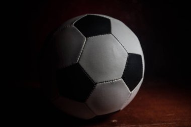 Futbol topu görünümünü koyu arka plan üzerine kapatın. Futbol oyun kavramsal atış. Seçici odak