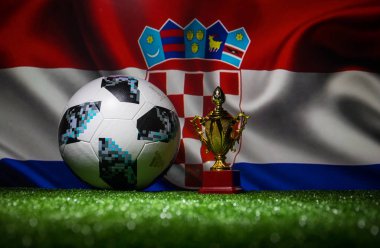 Bakü, Azerbaycan - 13 Temmuz 2018: Yaratıcı kavramı. Resmi Rusya 2018 Dünya Kupası futbol topu Adidas Telstar 18 ve şampiyon bir fincan yeşil çimenlerin üzerinde. Destek Hırvatistan takım kavramı. Seçici odak