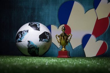 Bakü, Azerbaycan - 13 Temmuz 2018: Yaratıcı kavramı. Resmi Rusya 2018 Dünya Kupası futbol topu Adidas Telstar 18 ve şampiyon bir fincan yeşil çimenlerin üzerinde. Destek Fransa takım kavramı. Seçici odak