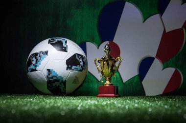 Bakü, Azerbaycan - 13 Temmuz 2018: Yaratıcı kavramı. Resmi Rusya 2018 Dünya Kupası futbol topu Adidas Telstar 18 ve şampiyon bir fincan yeşil çimenlerin üzerinde. Destek Fransa takım kavramı. Seçici odak