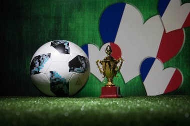 Bakü, Azerbaycan - 13 Temmuz 2018: Yaratıcı kavramı. Resmi Rusya 2018 Dünya Kupası futbol topu Adidas Telstar 18 ve şampiyon bir fincan yeşil çimenlerin üzerinde. Destek Fransa takım kavramı. Seçici odak