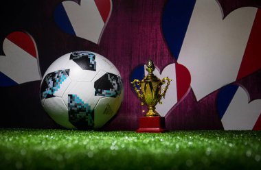 Bakü, Azerbaycan - 13 Temmuz 2018: Yaratıcı kavramı. Resmi Rusya 2018 Dünya Kupası futbol topu Adidas Telstar 18 ve şampiyon bir fincan yeşil çimenlerin üzerinde. Destek Fransa takım kavramı. Seçici odak