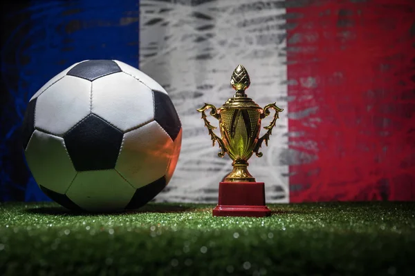 France flag, golden champion\'s cup and soccer ball on grass.Concept sport. Selective focus