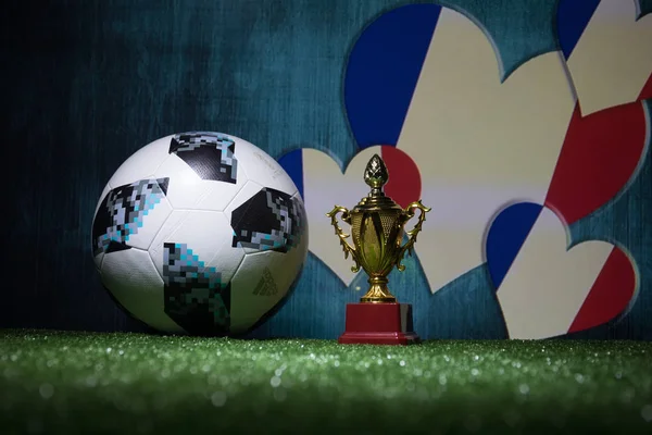 Bakü, Azerbaycan - 13 Temmuz 2018: Yaratıcı kavramı. Resmi Rusya 2018 Dünya Kupası futbol topu Adidas Telstar 18 ve şampiyon bir fincan yeşil çimenlerin üzerinde. Destek Fransa takım kavramı. Seçici odak