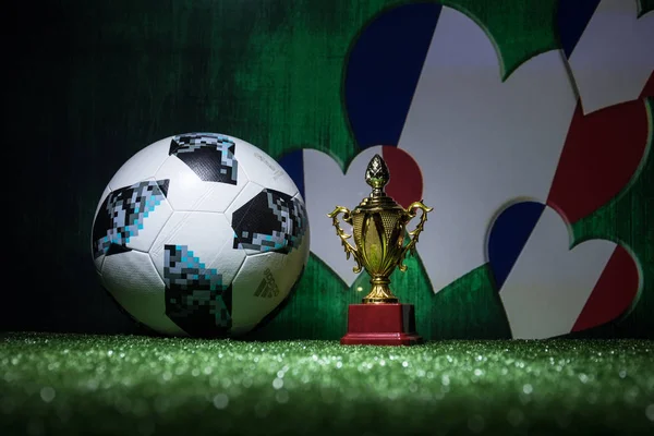 Bakü, Azerbaycan - 13 Temmuz 2018: Yaratıcı kavramı. Resmi Rusya 2018 Dünya Kupası futbol topu Adidas Telstar 18 ve şampiyon bir fincan yeşil çimenlerin üzerinde. Destek Fransa takım kavramı. Seçici odak