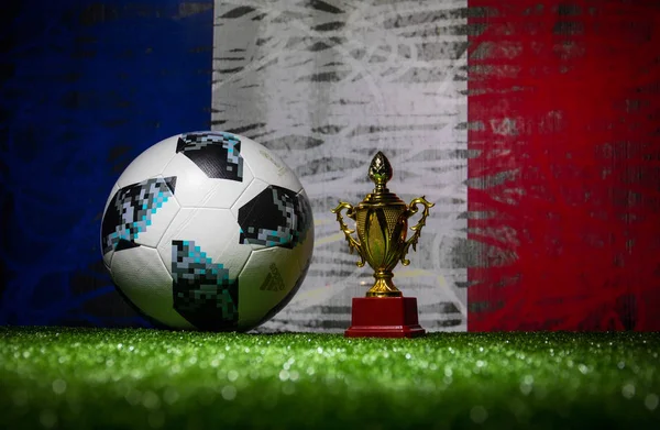 Bakü, Azerbaycan - 13 Temmuz 2018: Yaratıcı kavramı. Resmi Rusya 2018 Dünya Kupası futbol topu Adidas Telstar 18 ve şampiyon bir fincan yeşil çimenlerin üzerinde. Destek Fransa takım kavramı. Seçici odak
