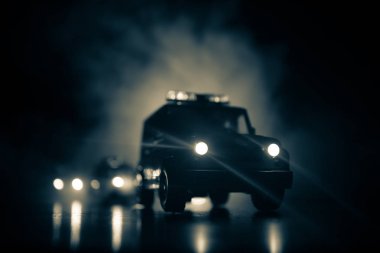 Police cars at night. Police car chasing a car at night with fog background. 911 Emergency response police car speeding to scene of crime. Selective focus clipart