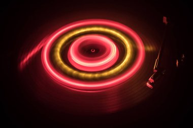 Müzik konsepti. FreezeLight parlak vinil koyu arka plan veya vinil parlayan Özet satırları konsepti ile koyu arka plan üzerinde oynarken pikap. Club poster tasarımı