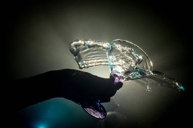 Martini kokteyl cam el koyu tonda dumanlı arka plan veya renkli kokteyl cam su sıçramalarına ve zeytin sıçramasına. Parti club eğlence. Karışık ışık. Seçici odak