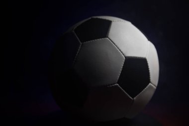 Futbol topu görünümünü koyu arka plan üzerine kapatın. Futbol oyun kavramsal atış. Seçici odak