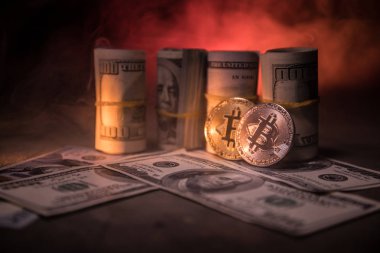 Bitcoin (sanal para) para ile toplu bize dolar koyu tonda sisli arka plan üzerinde. Seçici odak. Dijital para ve Bitcoin kavramı.