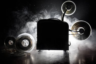 Eski stil film projektör, Natürmort, yakın çekim. Film projektör dramatik aydınlatma ve seçici odak ahşap bir zemin üzerine. Film ve eğlence kavramının