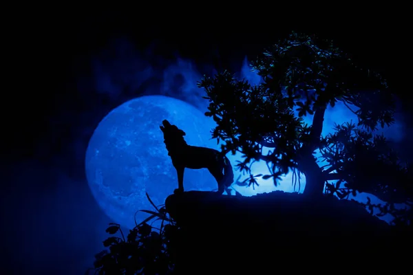 対ダーク ハウリング狼のシルエットは 満月にハウリング シルエットの霧の背景と満月やオオカミをトーンダウンしました ハロウィーン ホラー コンセプト 選択と集中 — ストック写真