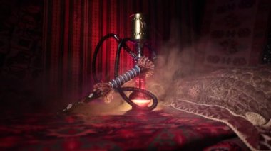 Nargile kömürü nargile kupa Arap iç de buhar bulutları yapma. Şark süsleme halı üzerinde. Şık oryantal shisha içinde karanlık arka ışık ile. Kaymak vurdu. Boş alan
