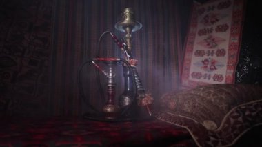 Nargile kömürü nargile kupa Arap iç de buhar bulutları yapma. Şark süsleme halı üzerinde. Şık oryantal shisha içinde karanlık arka ışık ile. Kaymak vurdu. Boş alan