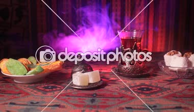 Vintage cam bir halı üzerinde Doğu atıştırmalıklar ile Arap tea. Doğu çay töreni ile ışık ve duman koyu arka plan üzerinde. Boş alanı. Seçici odak. Kaymak vurdu